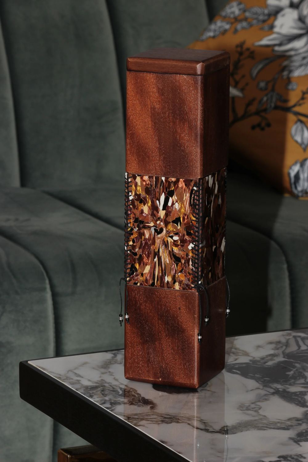 A handcrafted Memora capsule with a glowing amber mosaic panel